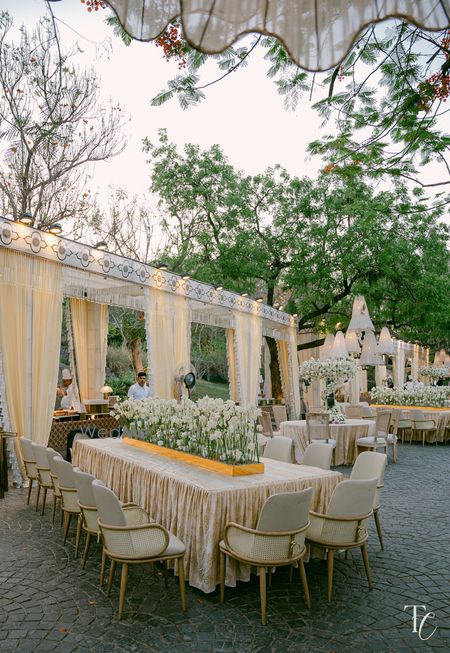 All white floral table setting for an open air wedding event 