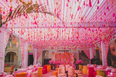 Photo of pink mehendi theme with gota tassels hanging from the tent