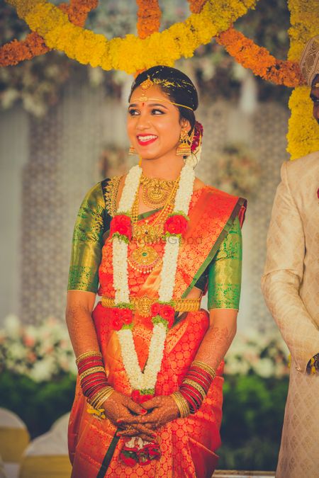 South Indian bridal saree in orange and gold with green blouse 