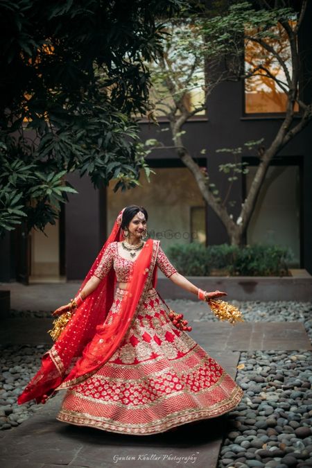 Photo of Twirling Sikh bride in red and gold bridal lehenga