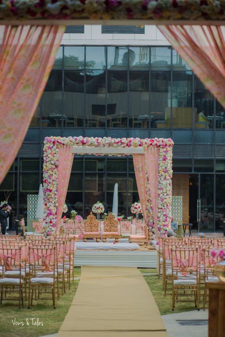 Photo of Floral drapes and light pink mandap with chairs