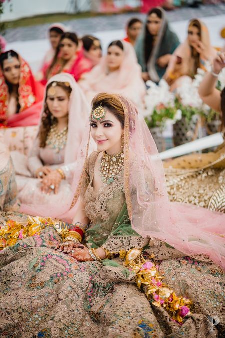 Sikh bride sitting for her anand karaj in a pink outfit