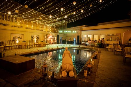 A poolside ceremony decorated with fairy lights