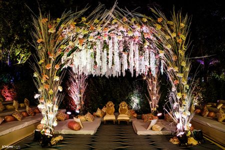 A mandap decorated with flowers and pampas grass.