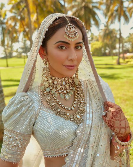 Stunning bridal jewellery haars and chokers, layered with a hint of jade hues with an all white lehenga