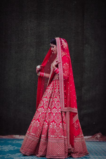 Photo of A bride in a red lehenga on her wedding day