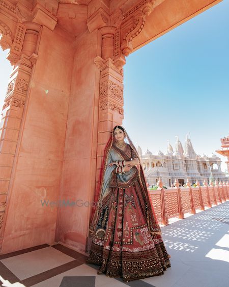Lovely bridal portrait with the bride in a brick red and blue lehenga with a double dupatta drape