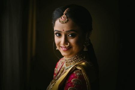 Happy bridal posing in beautiful gold jewellery. 