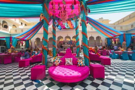 A colorful mehendi setup with tents, marigolds and dreamcatchers