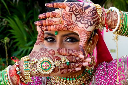 Photo of Bride posing showing off her bridal mehendi and haathphool
