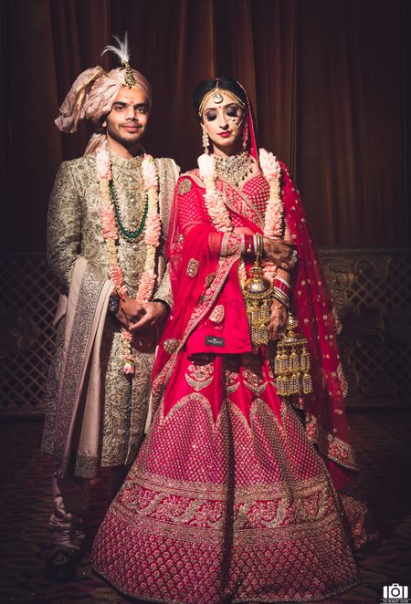 Photo of A beautiful couple portrait of a bride and groom dressed in red and gold.