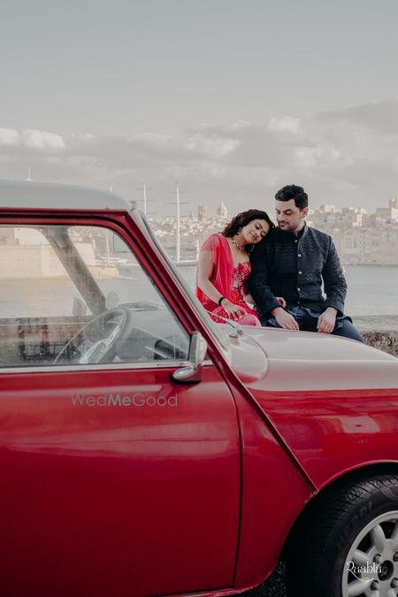 Pre wedding shoot shot against the waters and a vintage red car