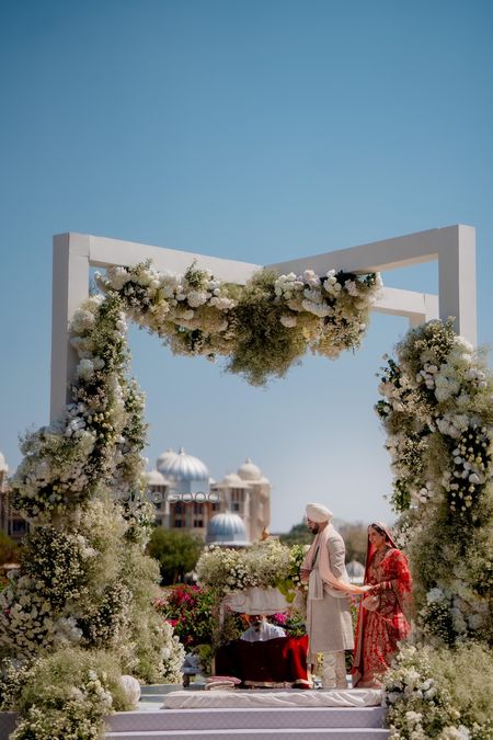 Unique mandap design with white floral decor for the wedding day