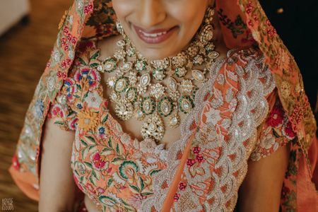 Photo of unique polki bridal necklace with orange lehenga