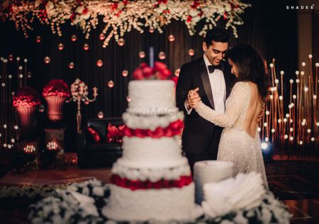 A couple dancing infront of a 3-tier cake on their reception