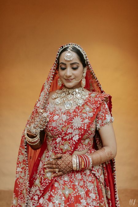 heavy bridal look in red anamika khanna lehenga and polki jewellery