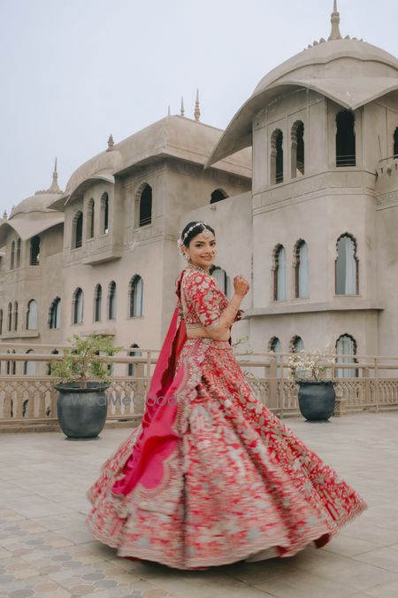 Photo of Gorgeous bright pink lehenga with the bride twirling on her wedding day