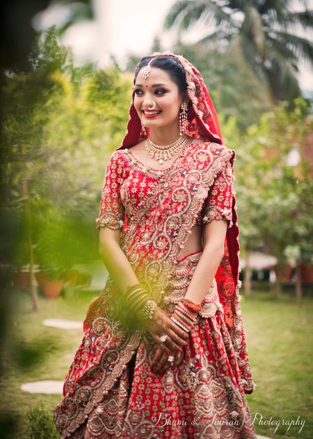 A bride in a red and gold applique work lehenga 