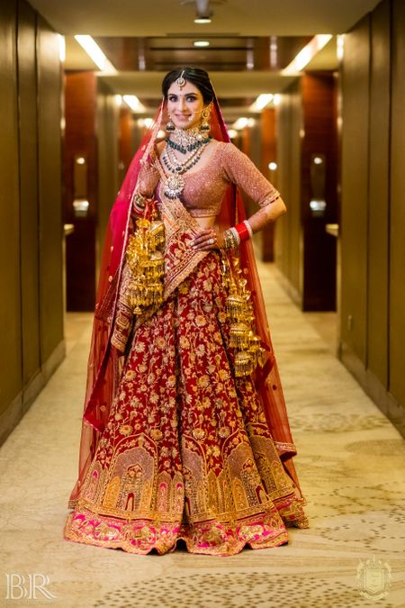 Photo of classic red bridal lehenga with unique gold embroidery