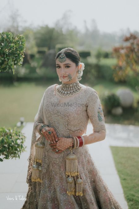 Photo of Gorgeous bridal portrait in a pastel lehenga and statement diamond jewellery with emerald detailing