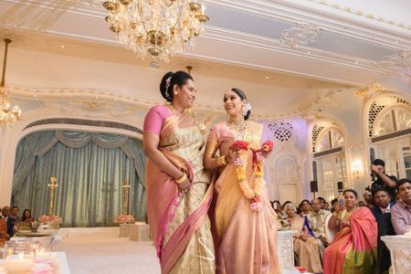 bride in light pink kanjivaram entering with her mom