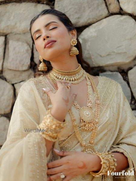 Vintage style bridal jewellery with layered necklaces in gold and traditional jhumkis.