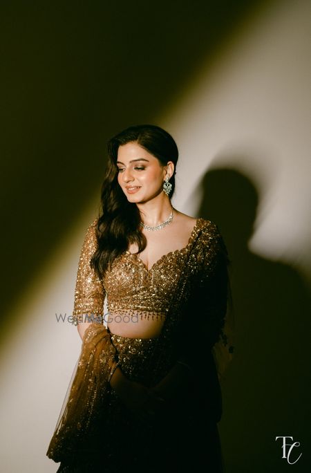 Minimalistic bridal look for the sangeet night with the bride in a gold lehenga