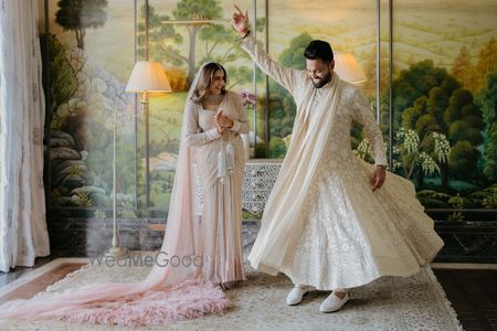 Photo of Fun candid moment between the couple just before the wedding in matching pastel outfits.