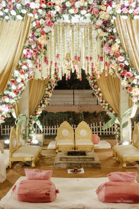 gold and white mandap decoration with white and pink florals