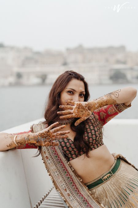 Cute bridal portrait of the bride posing with her mehendi design 