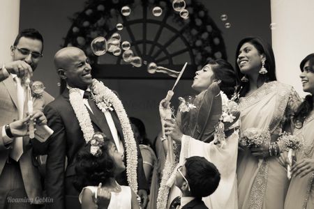 Photo of Bride blowing bubbles on groom