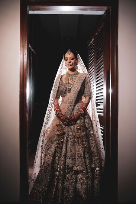 Bride in a pastel lehenga with silver detailing.