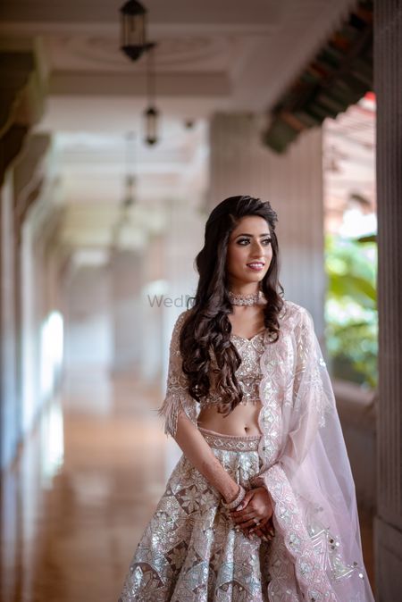 Long wavy hair and subtle makeup with pastel lehenga