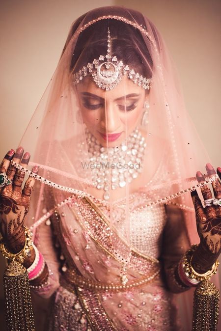 Stunning bride with light pink veil shot 