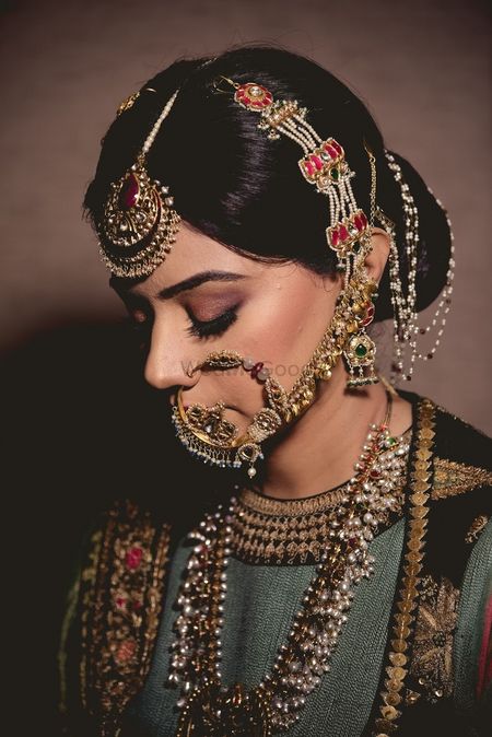 A bride with heavy jewelry, mangtikka an nath. d
