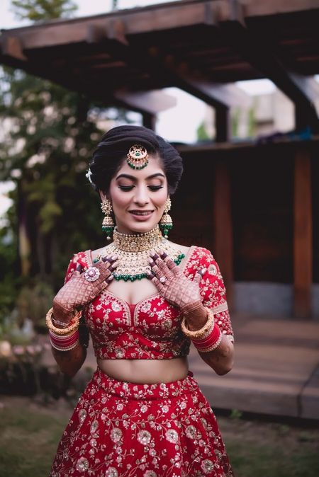 Bride in red blouse and green jewellery 