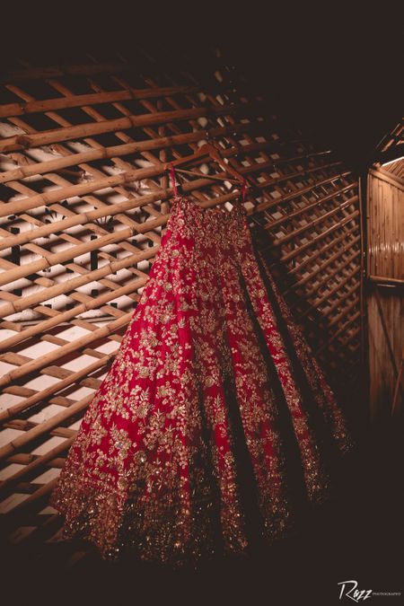red and gold simple bridal lehenga on hanger