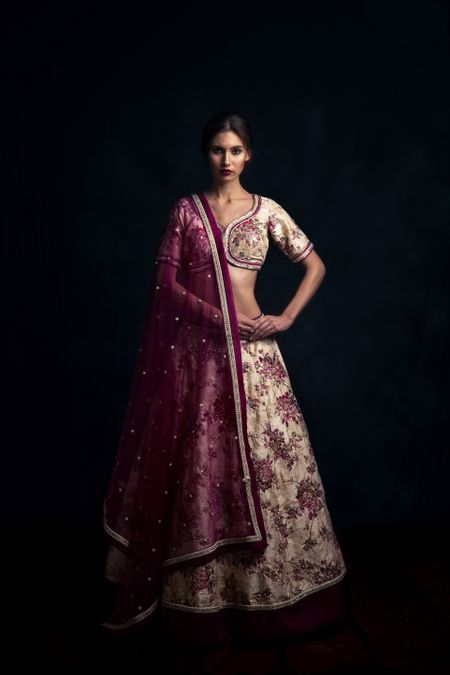 Photo of Offbeat bridal lehenga in off white with floral print and maroon dupatta