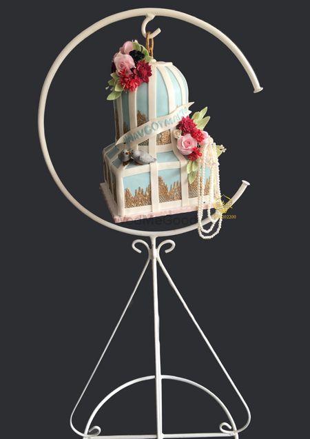 A two tier, suspended cake in white and blue colours