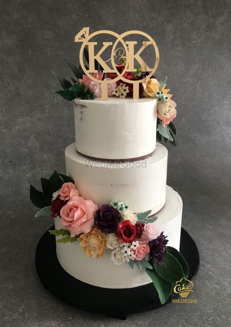 Photo of Three tier cake in white with floral decorations