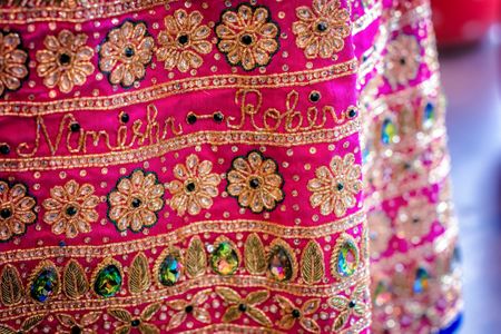 Bright pink lehenga with couple's names embroidered