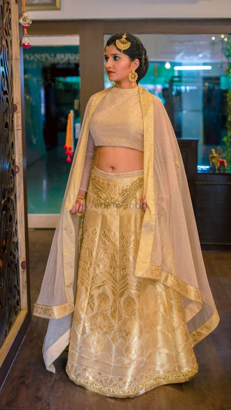 Photo of Gold and beige lehenga with cape
