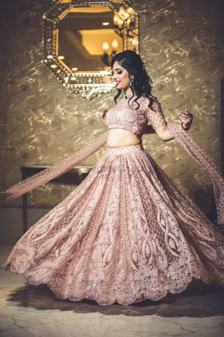 Twirling bride in onion pink lehenga with lace work