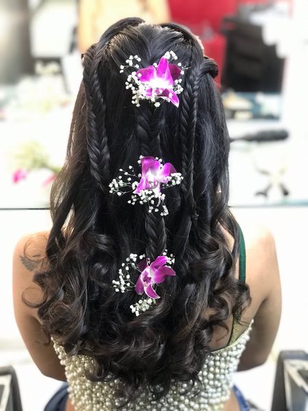 Braided hairdo with orchids in hair 