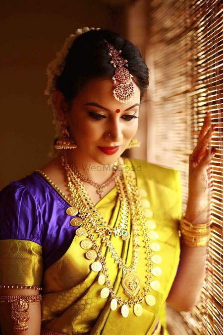 South Indian bride in yellow and purple saree