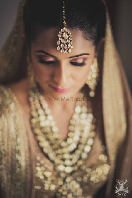 Bridal portrait with bride in gold makeup and lehenga