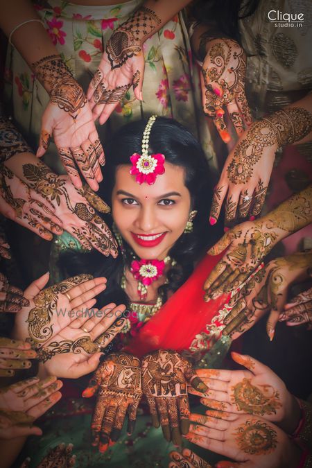 Photo of Bride and bridesmaids showing off mehendi bridal portrait