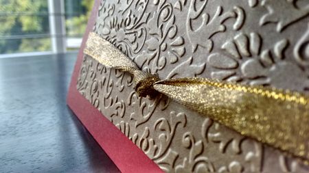 maroon and silver engraved card with ribbon