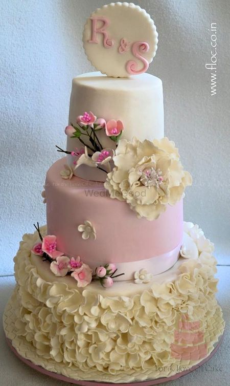 Photo of three tier pastel cake with flower detailing and cherry blossom