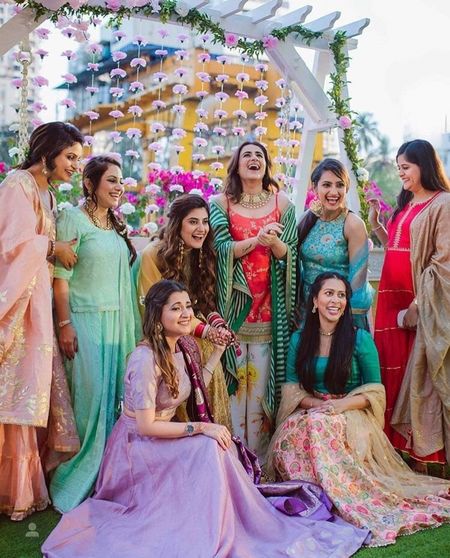Photo of Bride with bridesmaids in intimate mehendi
